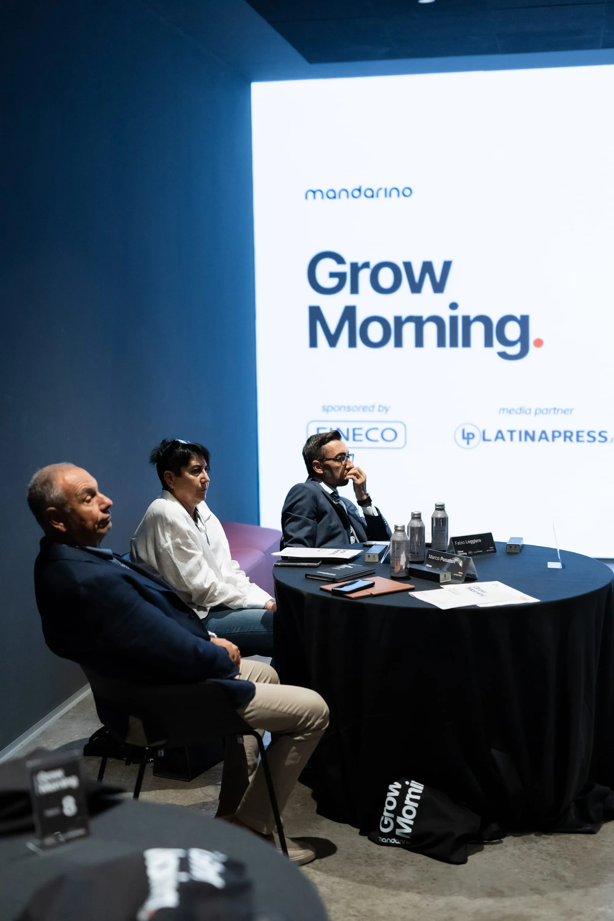 Il tavolo dei relatori davanti allo schermo con il logo GrowMorning.